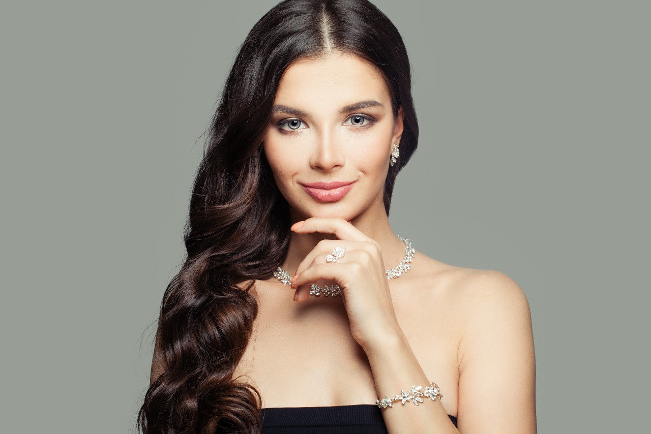 lady wearing platinum jewelry on a gray background