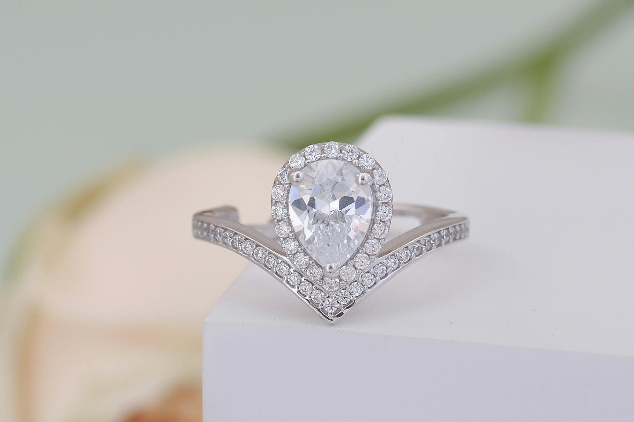 a platinum  engagement ring with a pear shaped diamond and halo