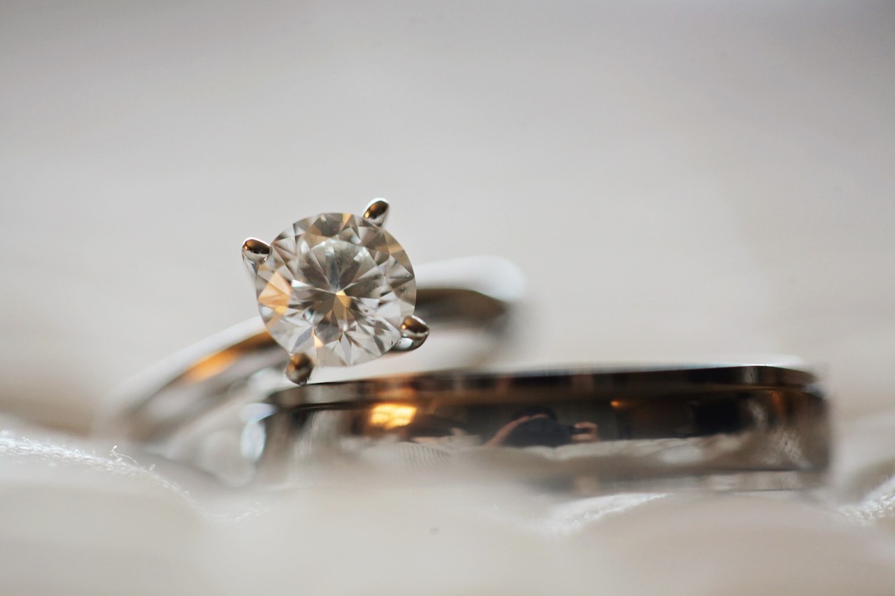 a white gold engagement ring and wedding band on a gray background