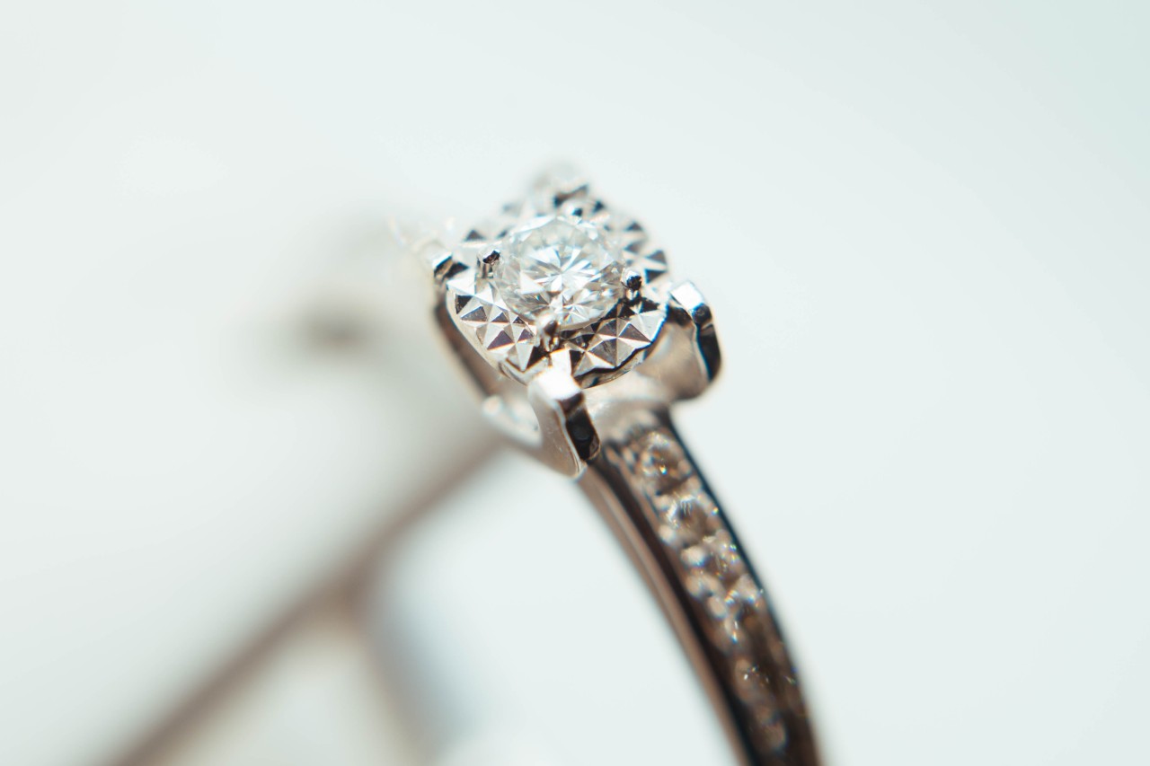 Engagement ring with round cut diamond center stone and channel setting on the band
