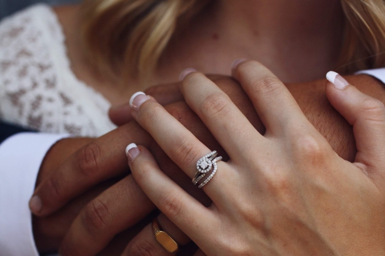 Engagement ring worn by a new bride accentuated by a wedding band