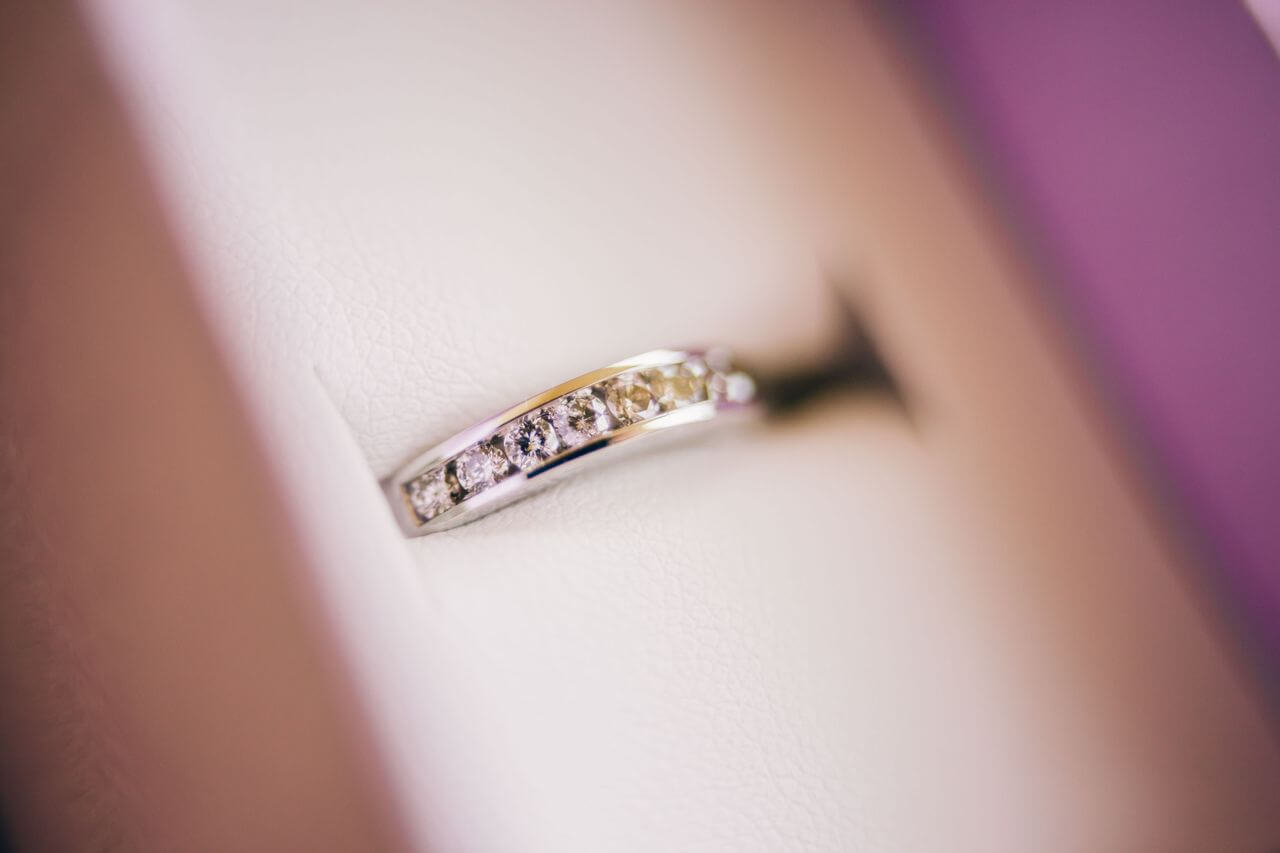 Close up image of a silver ladies’ wedding band with channel set diamonds