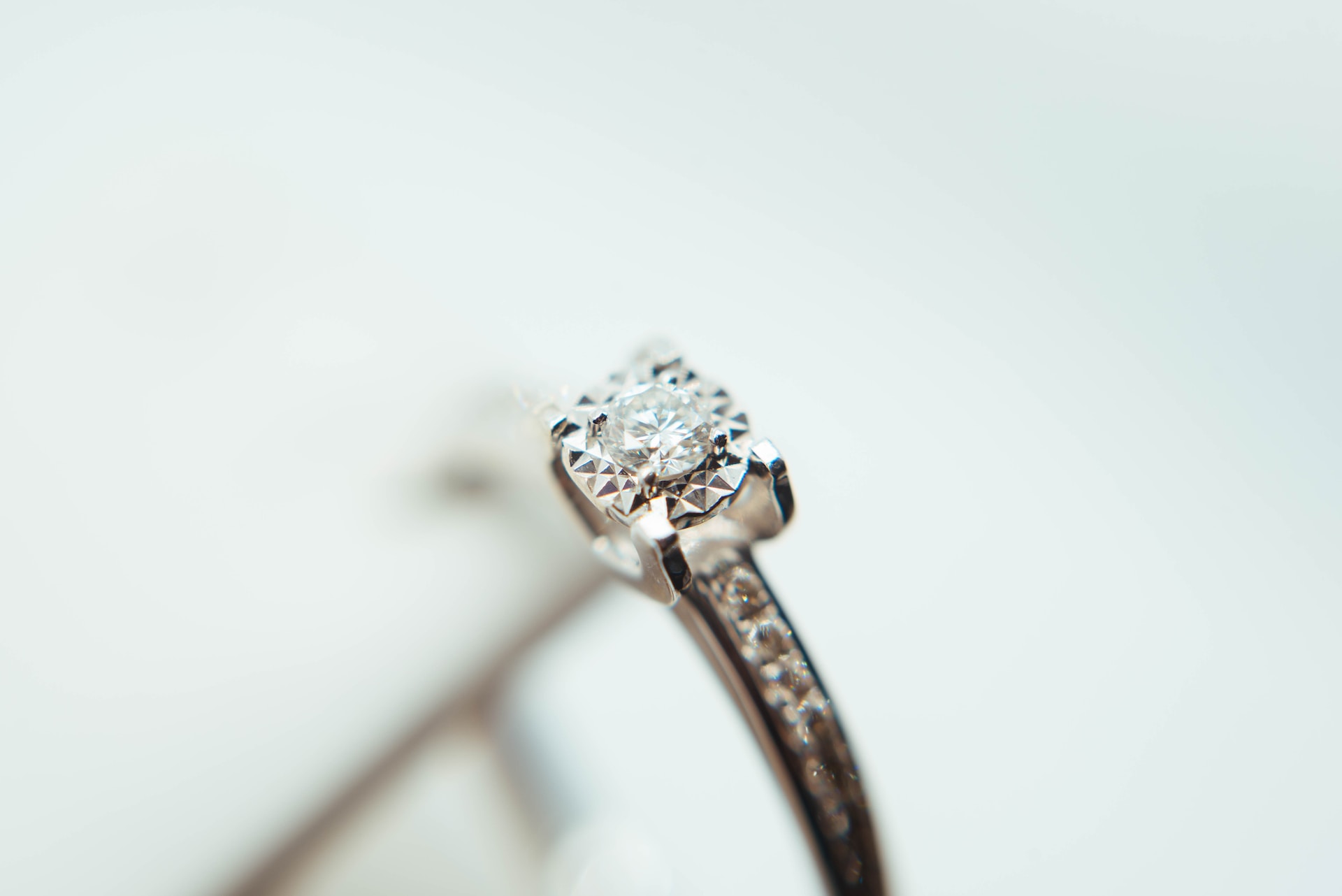 a white gold engagement ring with a round cut center stone and channel set side stones