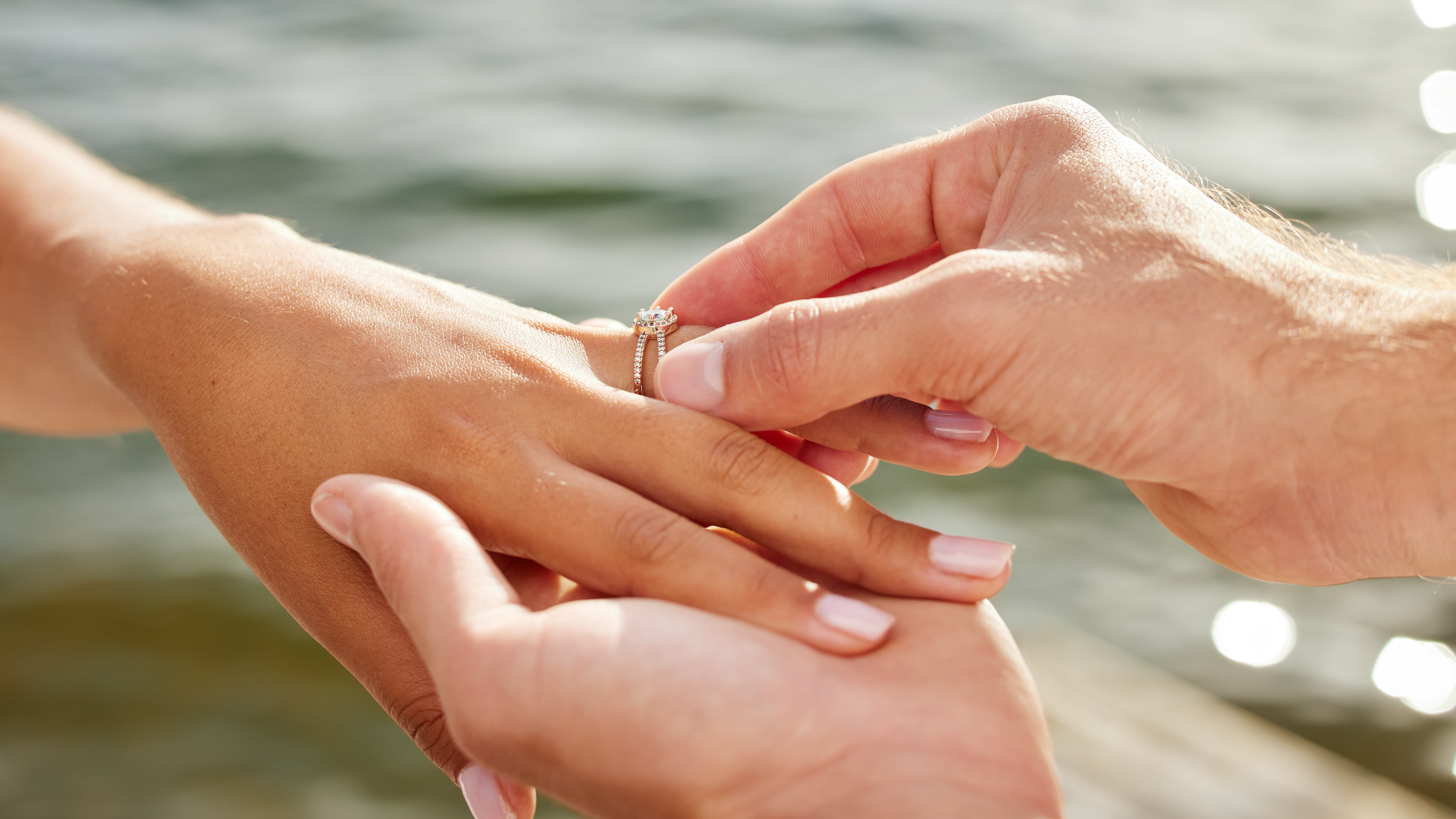 Banner of a man placing an engagement ring on a woman's finger