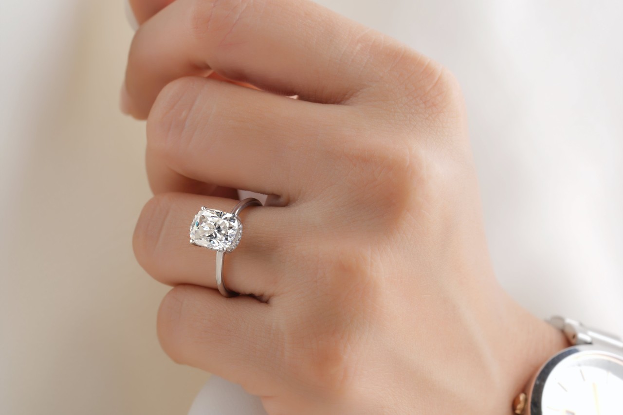 a lady’s hand wearing a simple engagement ring