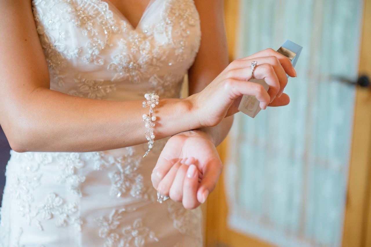 A view of a bride in her wedding dress preparing for her wedding, with emphasis on the diamond rings on her hands and the delicate bracelet on her wrist. A view of a bride in her wedding dress preparing for her wedding, with emphasis on the diamond rings on her hands and the delicate bracelet on her wrist.